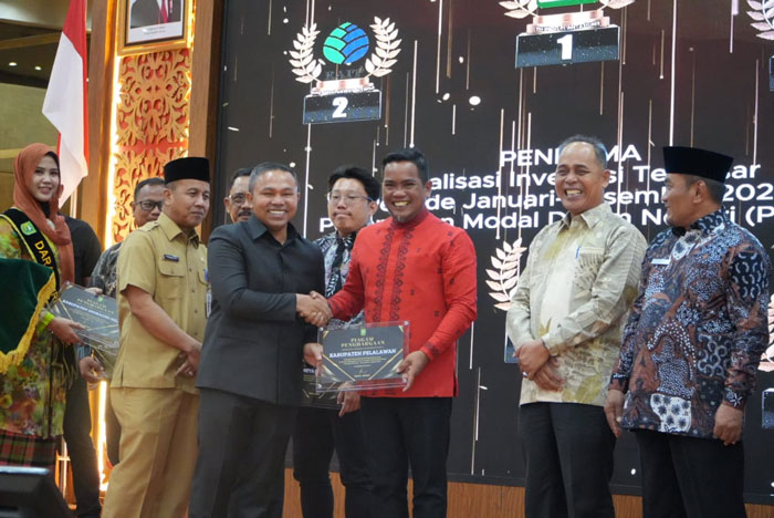 Gubri H Abdul Wahid serahkan penghargaan Terbaik I Penyumbang Realisasi Investasi Terbesar se-Riau Tahun 2024 yang diterima Bupati Pelalawan H Zukri, SM, MM di Ballroom Dang Merdu, BRK Syariah