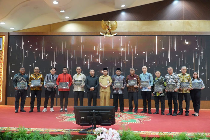 Gubri H Abdul Wahid foto bersama usai serahkan penghargaan Terbaik I Penyumbang Realisasi Investasi Terbesar se-Riau Tahun 2024 yang diterima Bupati Pelalawan H Zukri, SM, MM di Ballroom Dang Merdu