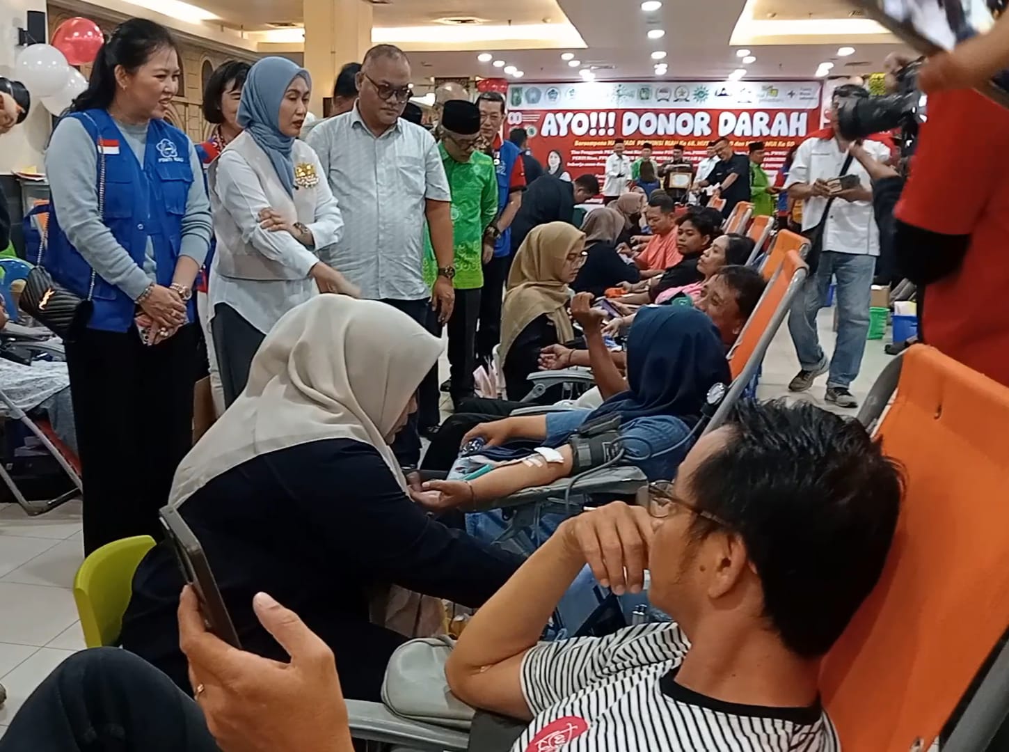 PLT Ketua PSMTI Riau Lindawati (jaket biru) mendampingi Ketua TP PKK Riau Henny Sasmita Wahid (tengah) mengunjungi para pendonor darah yang ditaja oleh PSMTI Riau di Mal Pekanbaru, Sabtu (30/8/2025).