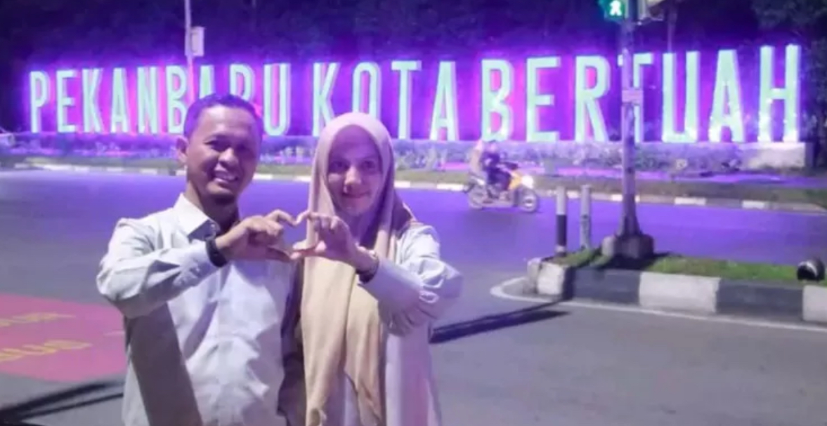 Wako Pekanbaru Agung Nugroho dan istri berfoto dengan latar belakang landmark bertuliskan Pekanbaru Kota Bertuah di Pusat Kota Pekanbaru.