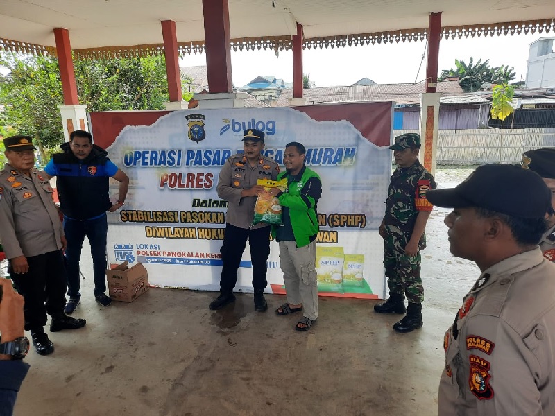 Kapolsek Pangkalankerinci AKP&nbsp;Tatit&nbsp;Rizkyan Hanafi SIK menyerahkan bantuan beras kepada salah seorang komunitas Ojol dalam pelaksanaan Gerakan Pangan Murah (GPM) di Tribun Lapangan Bola Mini Soccer.