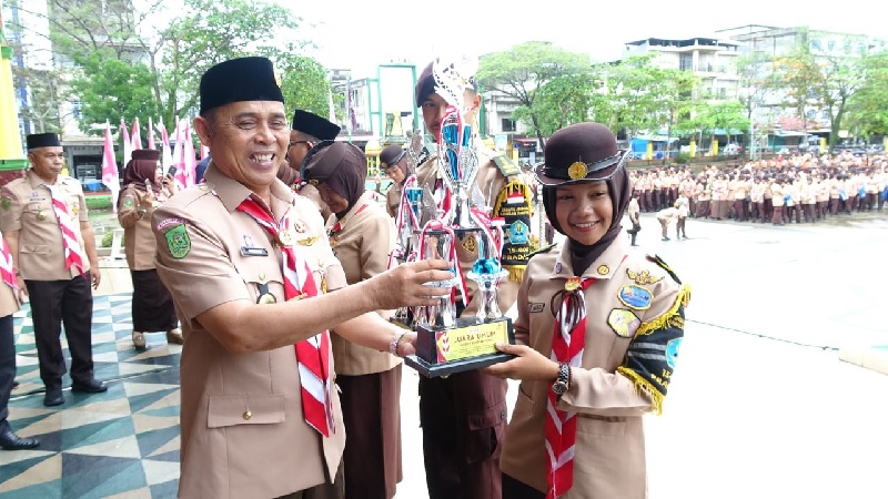 Bupati Inhil Herman menyerahkan piala kepada pemenang lomba dalam memperingati Hari Pramuka ke-64 di Lapangan Gajah Mada, Tembilahan, Selasa (2/9/2025).