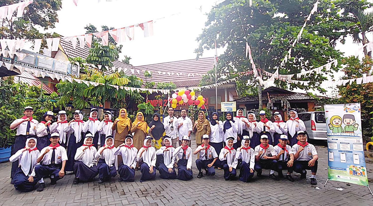 Tim pengabdian dosen Unri foto bersama kepala sekolah, guru dan pelajar SMPN 27 Pekanbaru usai peluncuran aplikasi berbasis web merahkuningku.id, Senin (1/9/2025).