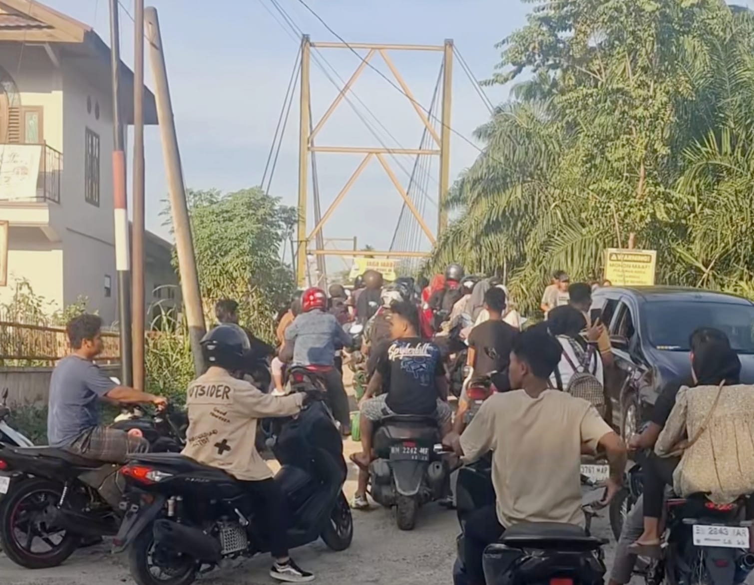 Lonjakan kendaraan roda dua dan roda empat silih berganti mengantre menuju Jembatan Gantung Lubuk Bendahara, Kecamatan Rokan IV Koto, Rohul, Ahad (7/9/2025).
