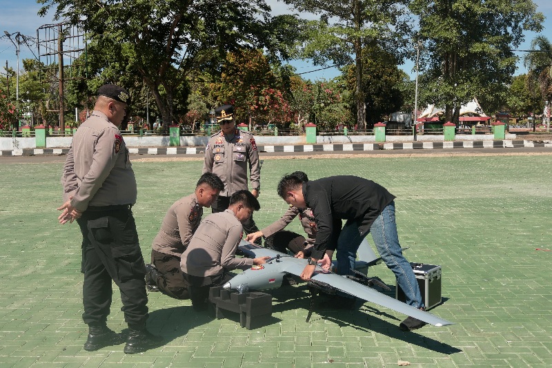 Kapolres Kuansing AKBP Raden Ricky Pratidiningrat SIK MH memantau drone UAV V-Tol untuk memantau PETI dari lapangan Taman Jalur, Sabtu (6/9/2025).