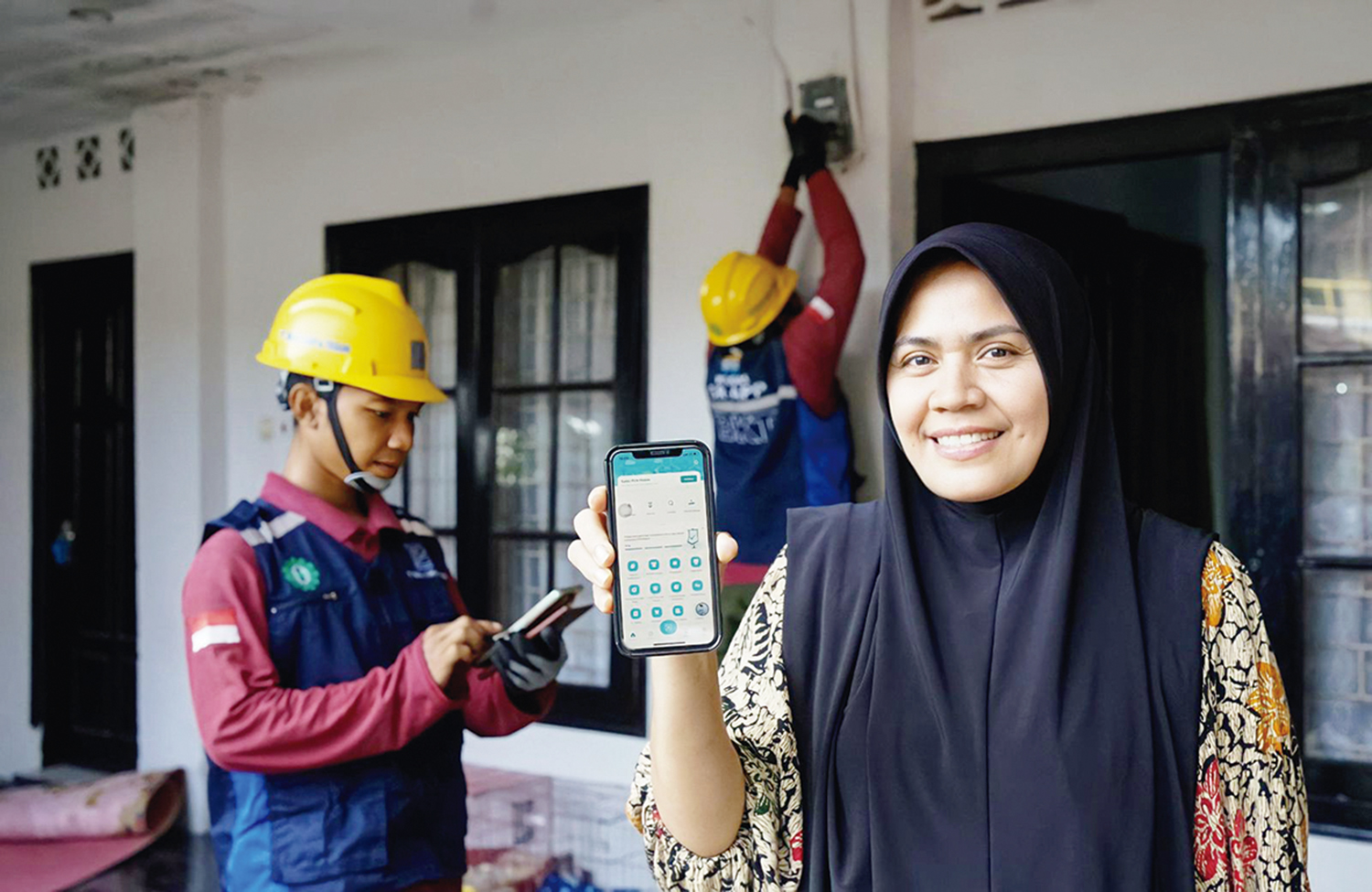 Pelanggan memperlihatkan aplikasi PLN Mobile.