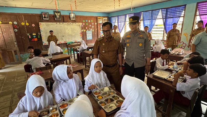 Kapolsek Singingi Hilir IPTU Alfredo Krisna Kaban bersama Camat Singingi Hilir Andhi Syamsul mengawasi pendistribusian makan bergizi gratis pada siswa di Kecamatan Singingi Hilir, Senin (8/9/2025)