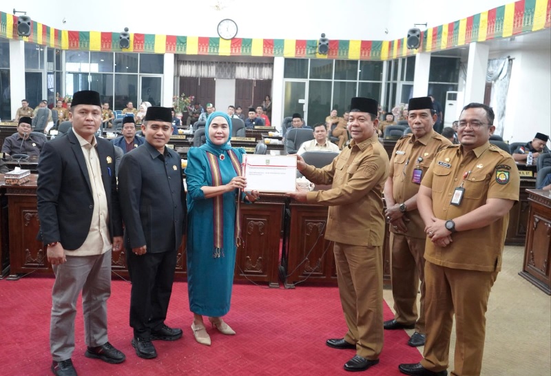 Wabup Rohul H Syafaruddin Poti SH MM menyerahkan dokumen rancangan KUA dan PPAS Perubahan Tahun Anggaran 2025 kepada Ketua DPRD Rohul Hj Sumiartini dalam rapat paripurna di Gedung DPRD, Senin (8/9).
