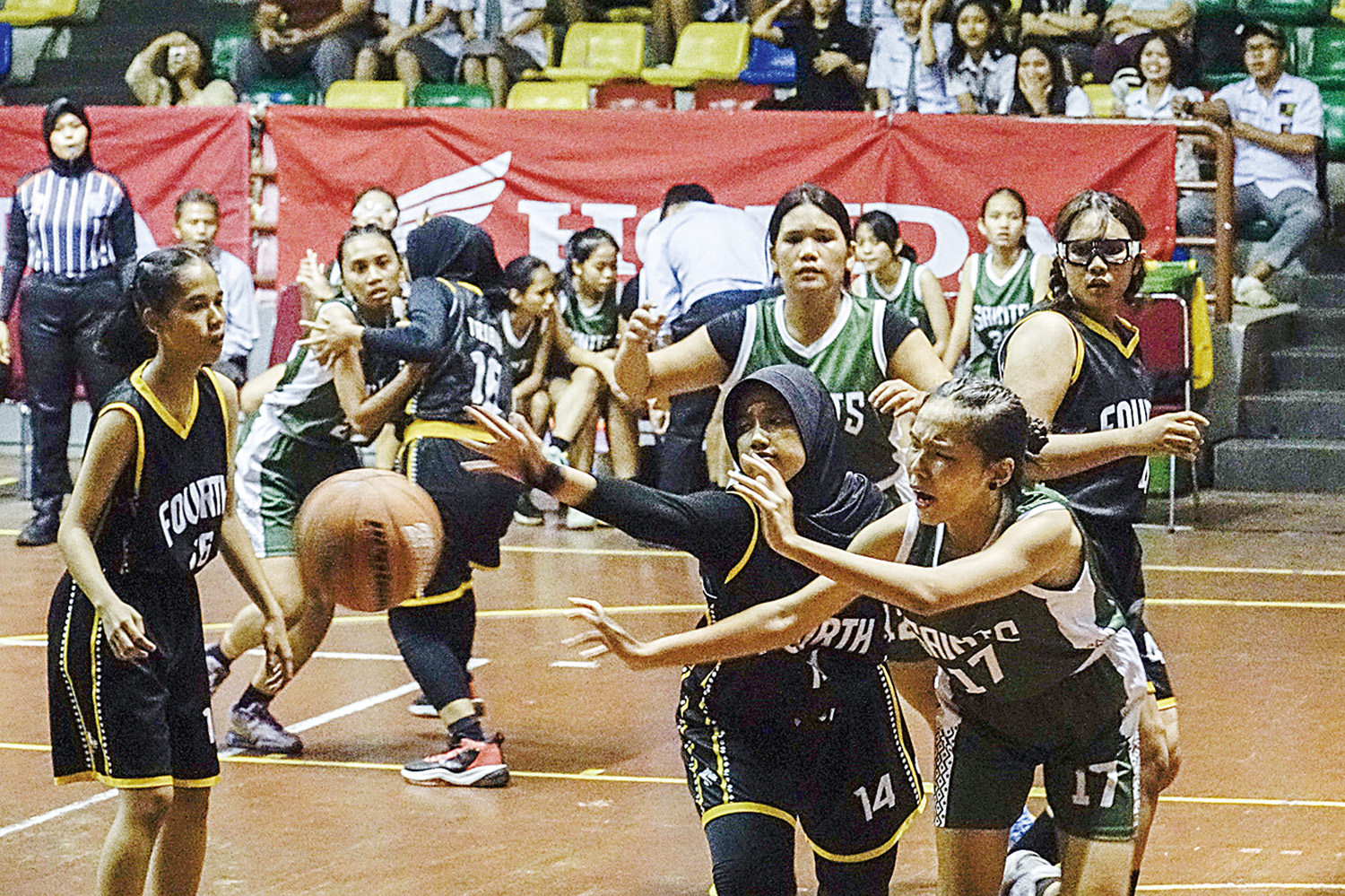 Pemain putri SMAN 4 Pekanbaru (hitam) berebut bola dengan pemain SMA Santa Maria (hijau) dalam laga pembuka Riau Pos-HSBL 2025 Pekanbaru Series di GOR Tribuana Pekanbaru.