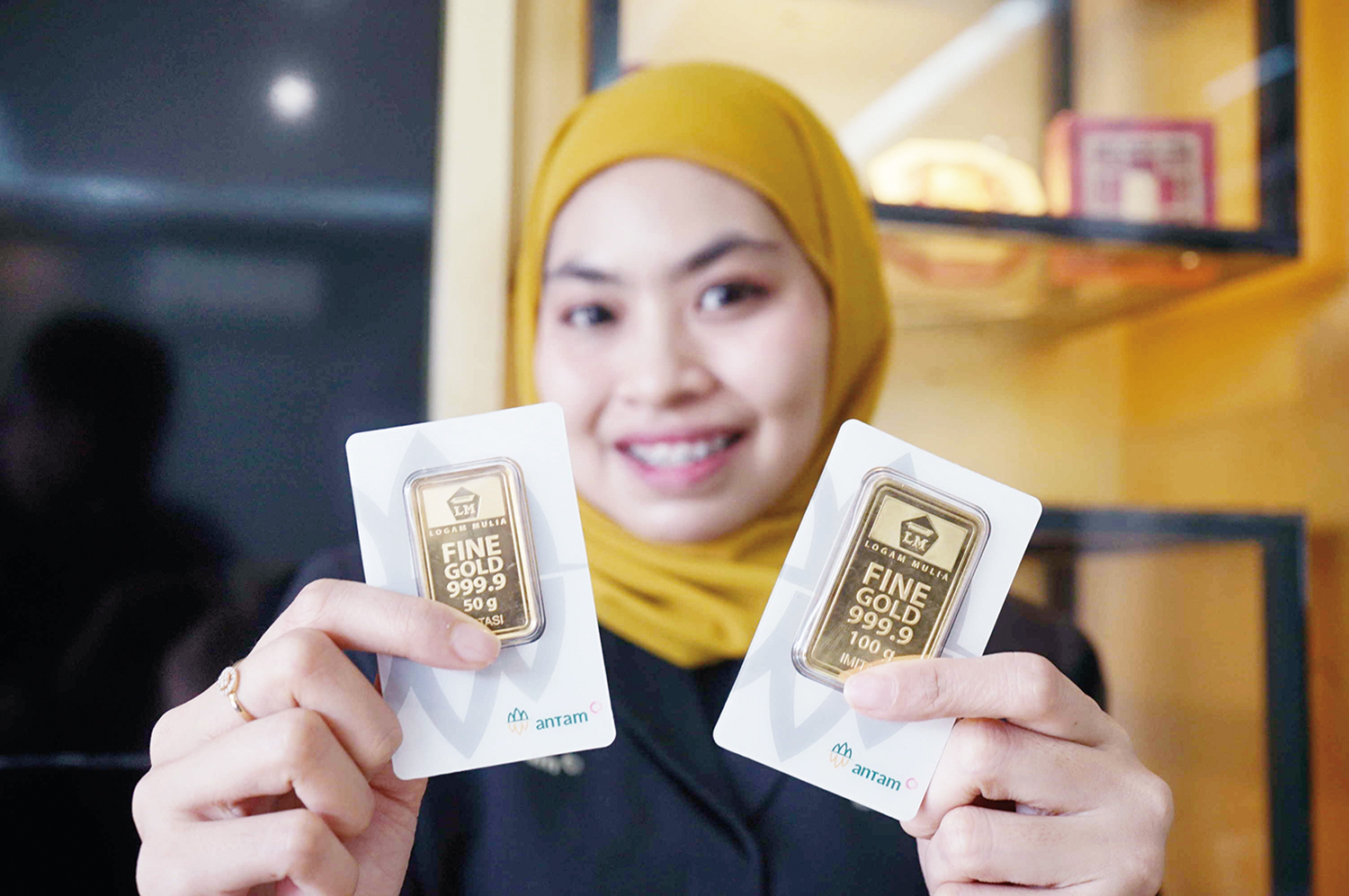 Seorang pegawai memperlihatkan kepingan emas Antam yang dijual di Galeri Emas Jalan Tuanku Tambusai, Pekanbaru, Selasa (9/9/2025).