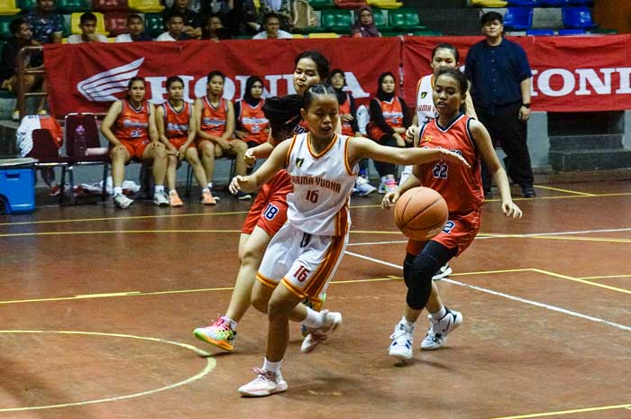 Pemain tim putri SMA Darma Yudha (putih) mendribel bola ketika berhadapan dengan SMAN 8 Pekanbaru (merah) pada laga Riau Pos-HSBL 2025 Pekanbaru Series di GOR Tribuana Pekanbaru, Kamis (11/9/2025).