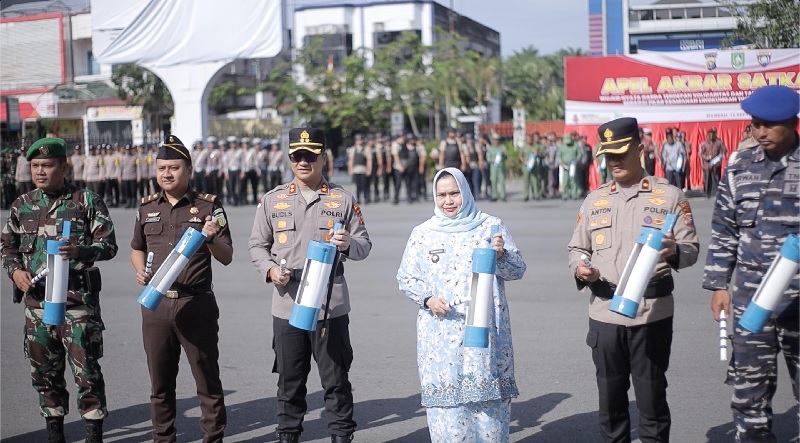 Bupati Bengkalis Kasmarni dan Kapolres AKBP Budi Setiawan memukul ketontog alat yang digunakan petugas siskamling untuk memberitahu warga akan bahaya di Lapangan Kantor Camat Mandau, Jumat (12/9/2025)