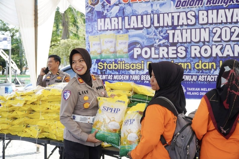 Kasatlantas AKP Lily Syulfiani SIK MH secara simbolis menyerahkan beras SPHP kepada perwakilan masyarakat yang membeli dengan harga terjangkau dalam kegiatan GPM di Taman Kota Pasirpengaraian, Senin.