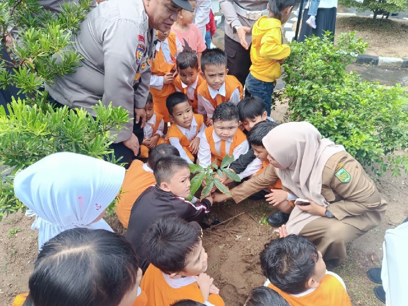 Anak-anak TK Bhayangkari melakukan penanaman pohon melalui program Kapolda Riau Green Policing di TK Bhayangkari Tembilahan Hulu, Senin (15/9/2025).