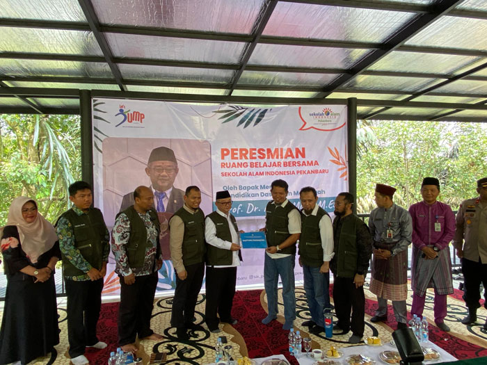 Mendikdasmen Prof Abdul Mu&rsquo;ti menyerahkan bantuan kepada sekolah alam Indonesia Pekanbaru, Jumat (19/9/2025).