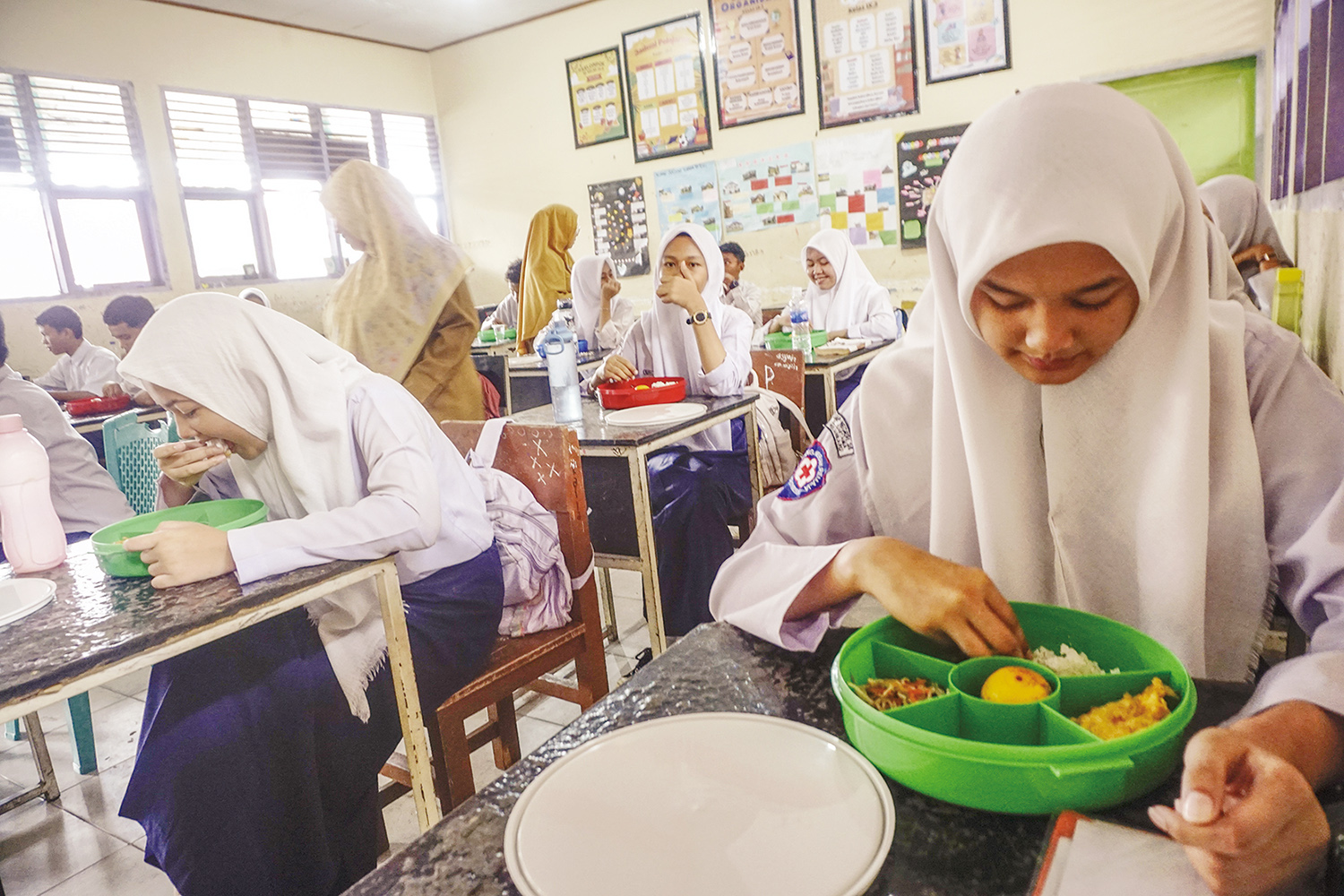 MAKAN:  Pelajar menikmati makan bergizi gratis di SMPN 25 Jalan Kertama,  Kelurahan Perhentian Marpoyan, Kecamatan Marpoyan Damai, Pekanbaru, beberapa waktu lalu.