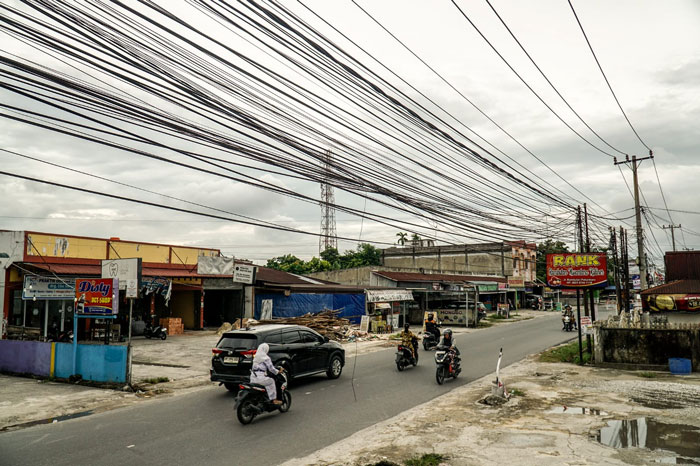 Kabel Fiber Optic yang semrawut di kawasan Jalan Rambutan, Pekanbaru, Senin (22/9/2025).