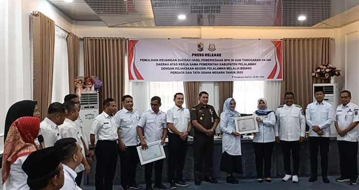 Bupati Pelalawan H Zukri didampingi Kepala Bapenda Pelalawan, Hj Jahlelawati menyerahkan penghargaan kepada masyarakat taat pajak di kantor Bapenda Pelaawan, baru-baru ini.