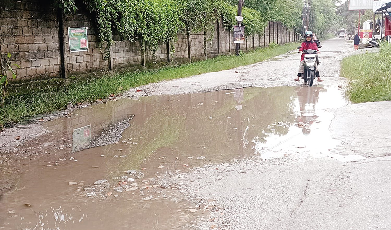 Pengendara sepeda motor menghindari lubang di Jalan Merpati Sakti, Kecamatan Binawidya, Pekanbaru, Senin (22/9/2025).