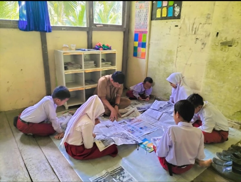 Pelajar SDN 007 Panglima Raja, Concong, Inhil tengah membaca koran untuk meningkatakan literasi dan ilmu pengetahuan, Selasa (23/9/2025).