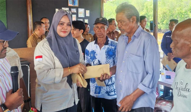 Manager Humas PT BLJ, Elmiawati Safarina menyerahkan bantuan uang tunai kepada korban kebakatan di Dusun Bukit Batu Laut, Kecamatan Bukit Batu, Selasa (23/9/2025).