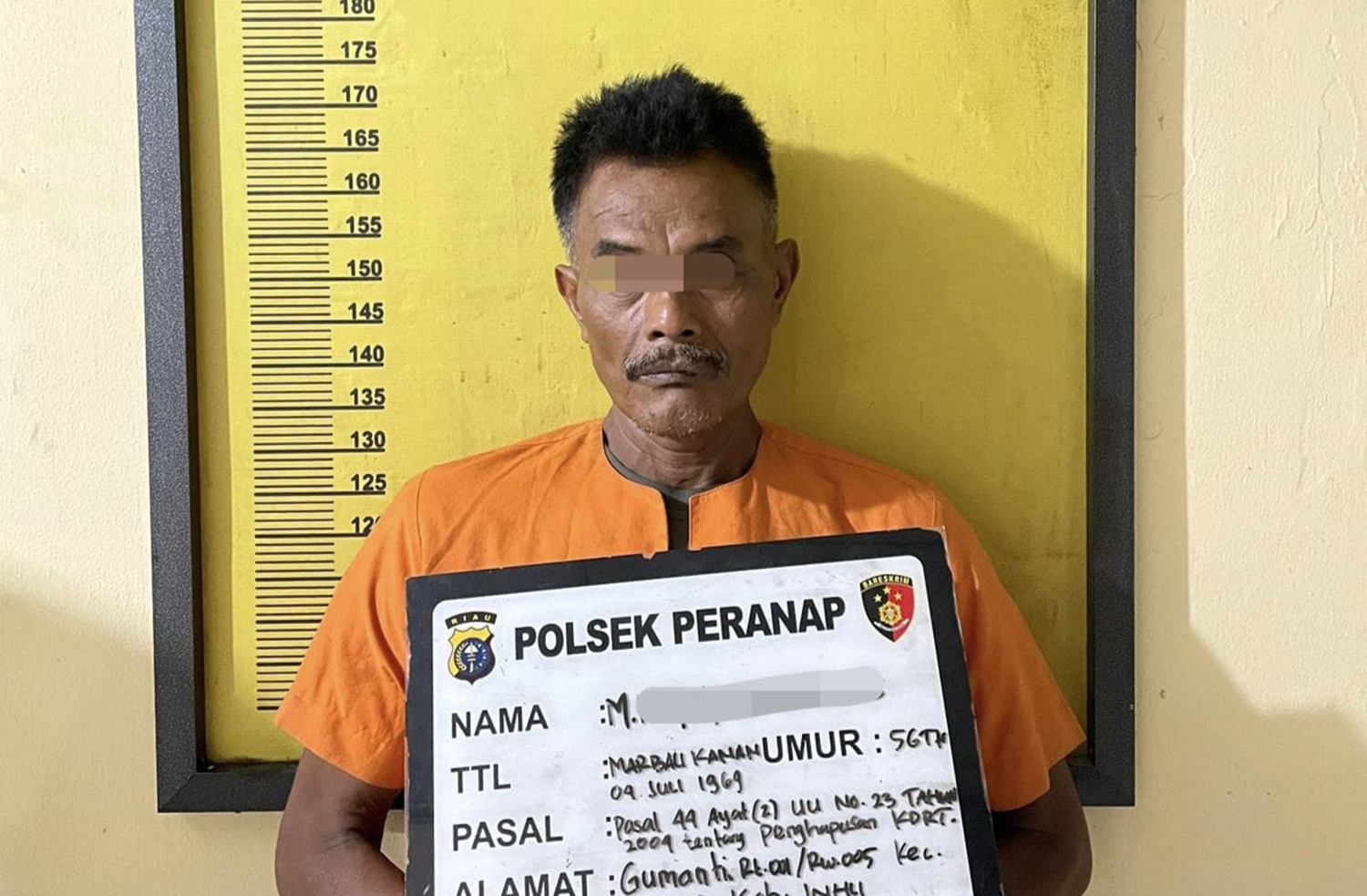 Tersangka peng- aniaya istri berinisial MR saat diamankan Polsek Peranap, Selasa (23/9/2025).