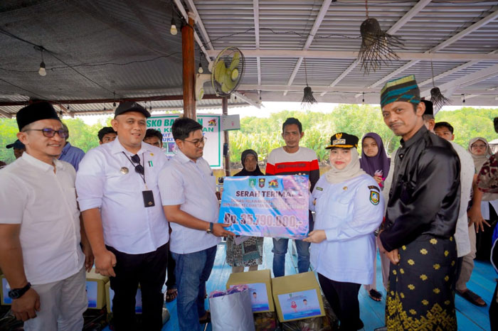 Bupati Bengkalis Kasmarni menyerahkan donasi yang berhasil dihimpun relawan dan LAMR Bukitbatu kepada korban kebakatan rumah, di dusun bukit batu, Rabu (24/9/2025).