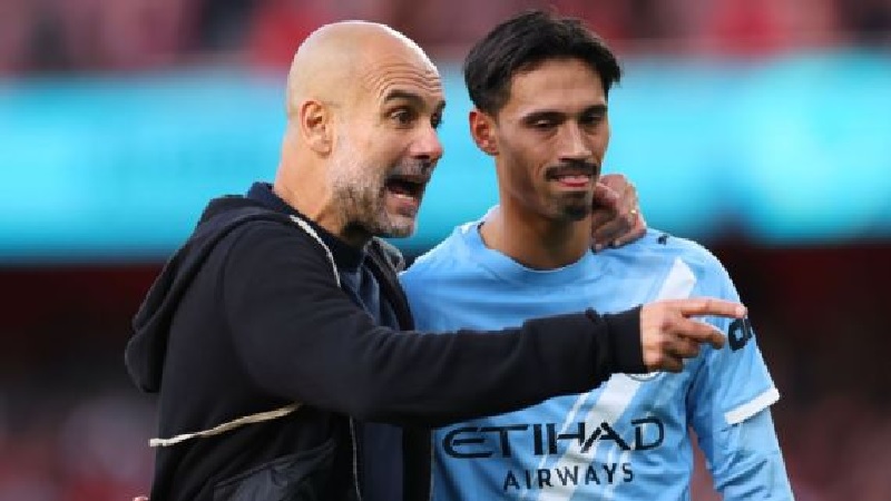 Pep Guardiola berjalan bersama Tijjani Reijnders saat pertandingan Manchester City melawan Arsenal.
