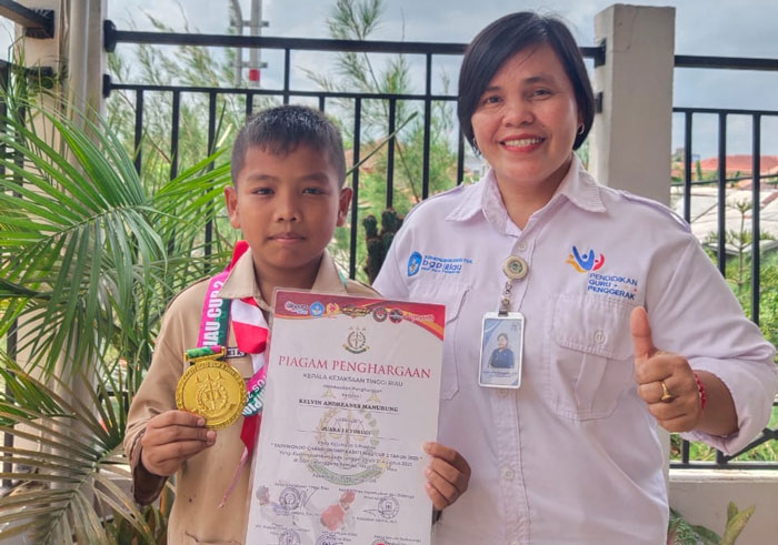 Kevin Andreanes Manurung pelajar SD 037 Kasih Lestari Tembilahan (kiri) meraih medali emas Taekwondo Kajati Riau 2025 di Pekanbaru, Kamis (25/9/2025).
