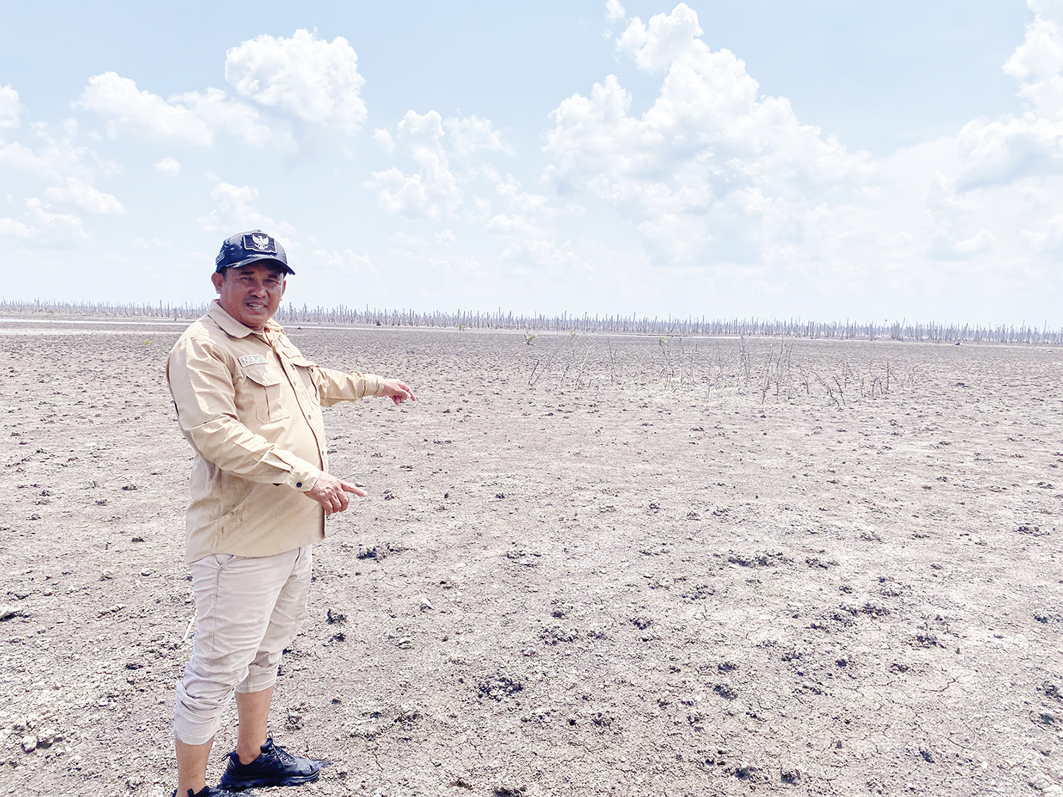 Kepala Desa Kuala Selat Nurjaya memperlihatkan bekas kebun kelapa milik masyarakat yang rusak akibat abrasi air laut, Kamis (25/9/2025).