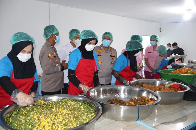 Kapolres Pelalawan AKBP John Louis Letedara SIK melakukan pengecekan kebersihan dan hiegenis makanan saat meluncurkan pendistribusian perdana Makan Bergizi Gratis (MBG) untuk ribuan pelajar.