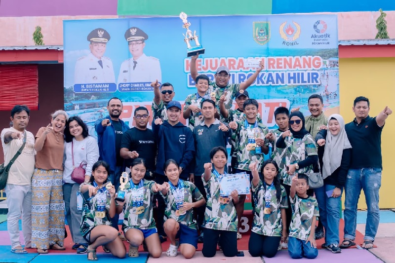 Ketua Federasi Akuatik Indonesia (FAI) Rohil M Fauzi foto bersama dengan tim Wira Bima Swimming Club usai penyerahan piala juara umum I.