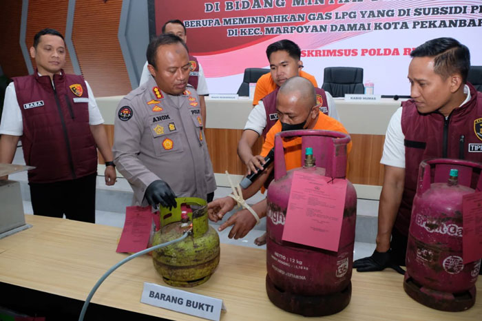 Kabid Humas Polda Riau Kombes Pol Anom Karibianto saat menunjukan barang bukti gas 3 Kg yang dioplos menjadi gas 5,5 kg dan 12 kg saat ekspos di Mapolda Riau, Rabu (1/10/2025).