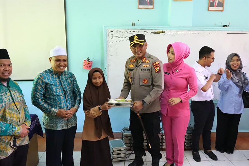 Kapolres Siak AKBP Eka Ariandy Putra bersama Ketua Bhayangkari Ny Eka Priyanti Ariandy, menyerahkan MBG kepada pelajar SMP Islamic Centre disaksikan Pengelola Yayasan Nizamul Muluk, Kamis (2/10/2025).
