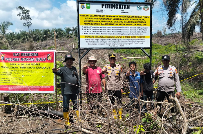 Kapolsek Rambah Samo Ipda Sarlose Mesra SH (dua kiri) foto bersama usai memasang plang peringatan di lahan bekas terbakar di Desa Rambah Samo, Kamis (2/10/2025).