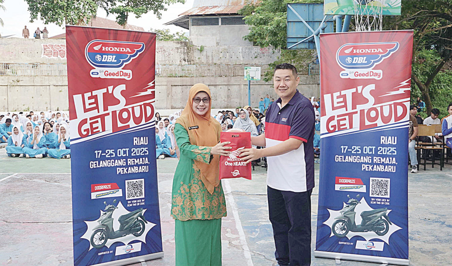 Promotion Section Head PT Capella Dinamik Nusantara Hariyanto Budhiman (kanan) menyerahkan cendera mata kepada Plt Kepala SMAN 8 Pekanbaru Hj Sulismayati MSi saat roadshow Honda DBL with Kopi Good Day 2025 Riau di SMAN 8 Pekanbaru, Jumat (3/10/2025).