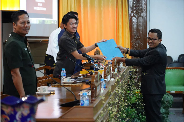 Juru bicara Fraksi Nasdem-PKS, Syafril ST menyerahkan pandangan umum fraksi pada Wakil Ketua I DPRD, Satria Mandala Putra saat paripurna, pandangan umum tentang Ranperda Masyarakat Hukum Adat (MHA).