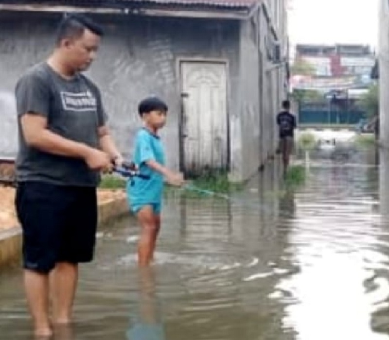 Sejumlah warga Jalan Beringin Kelurahan Pangkalan Kerinci Kota Kecamatan Pangkalan Kerinci melakukan aktivitas memancingbikan di Jalan Beringin yang direndam banjir namun tak kunjung dilakukan penangg