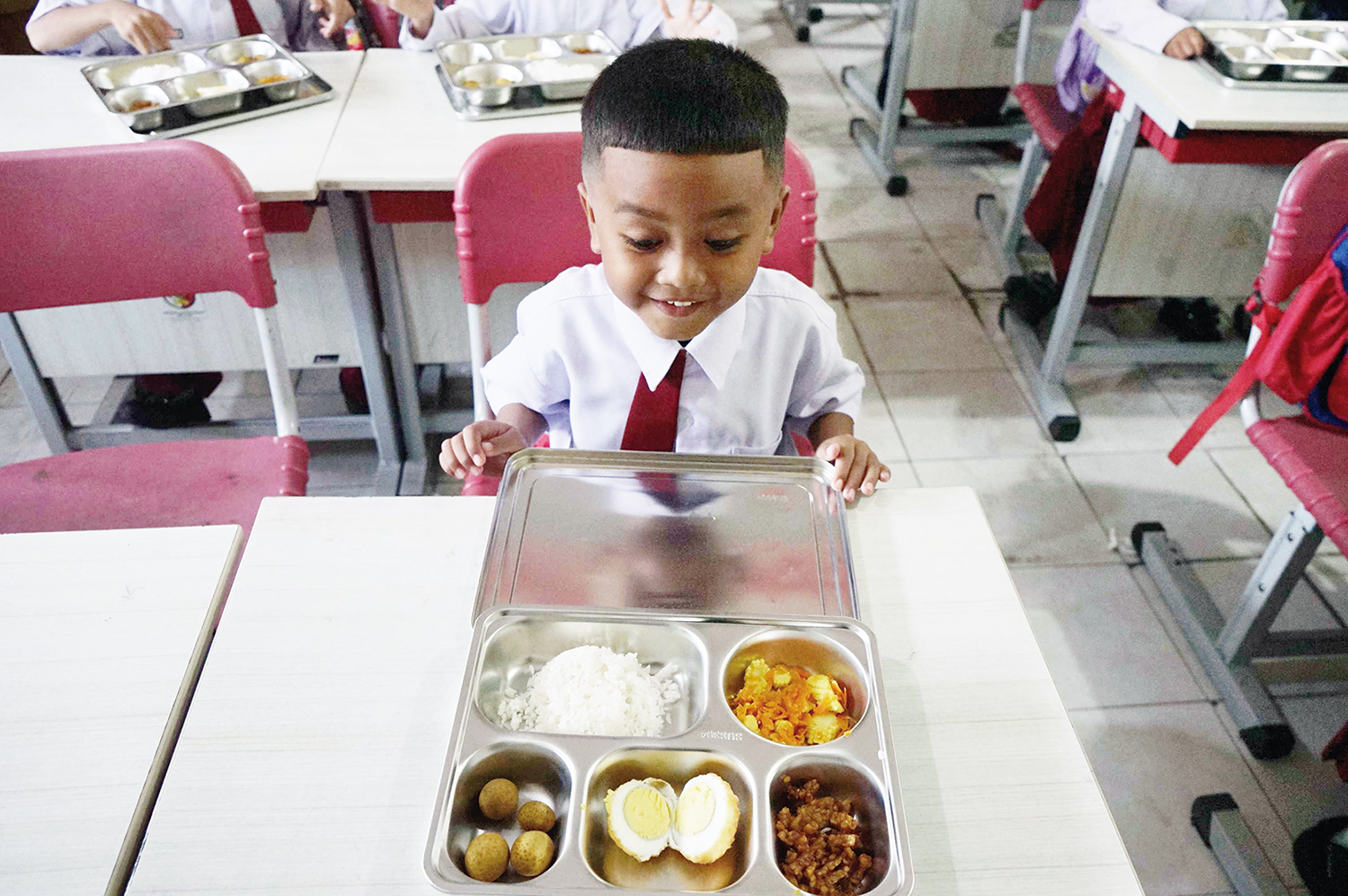 Seorang murid bersemangat melihat menu Makan Bergizi Gratis di SDN 99 Pekanbaru, Senin  (6/10/2025).