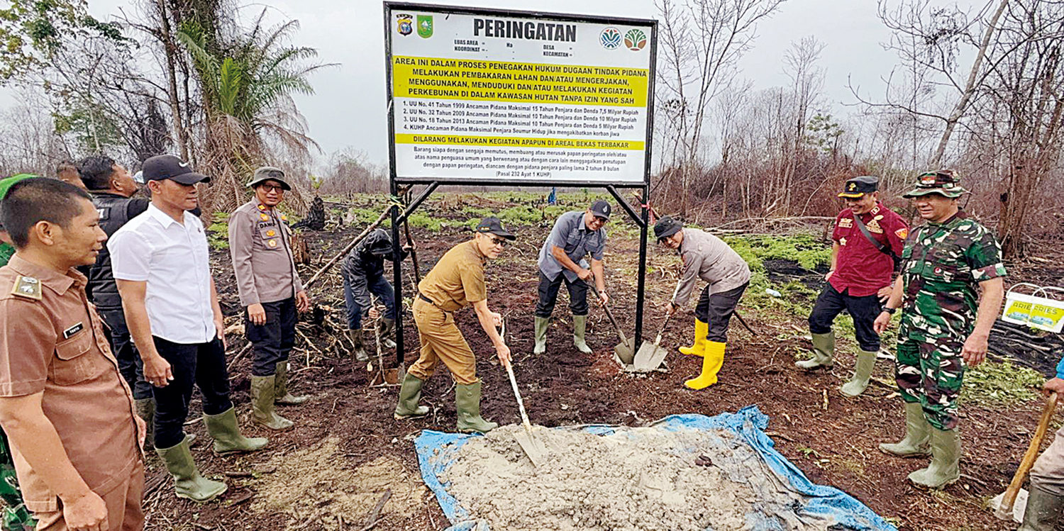 PLANG LARANGAN: Kapolres Inhil AKBP Farouk Oktora SIK bersama Asisten I Setdakab Inhil Fajar Husein dan Ketua DPRD Inhil Iwan Taruna memasang plang larangan beraktivitas di lahan bekas karhutla di Dusun Teluk Bagus, Desa Bayas, Kempas, Inhil, Senin (6/10/