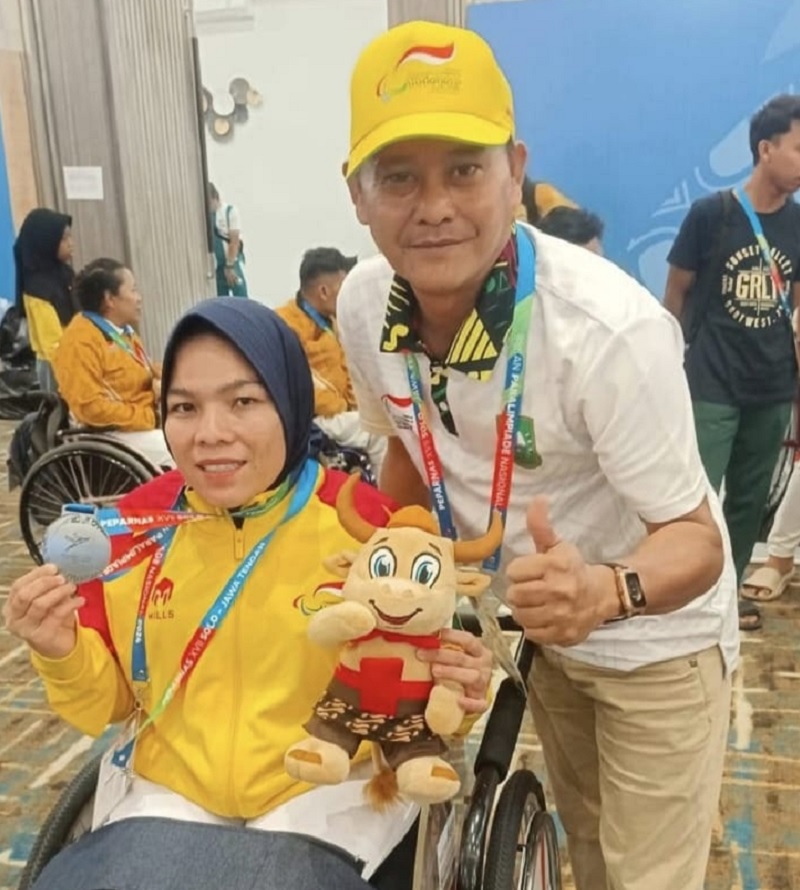 Ketua NPCI Rohul Piyus mendampingi Atlet Niken meraih medali saat mengikuti Cabor Anggar Kursi Roda mewakili Riau pada Papernas XVII di Solo tahun 2024i.