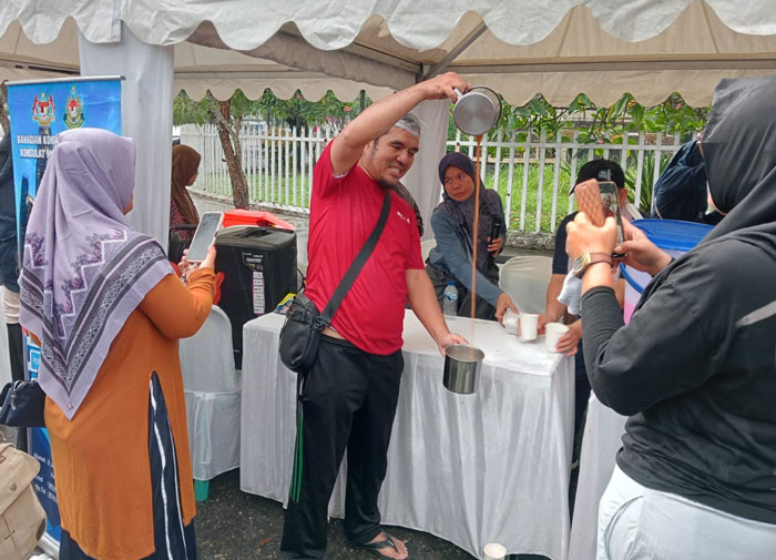 Pengunjung CFD terlihat menikmati atraksi pembuatan teh tarik yang menjadi salah satu ciri khas kuliner Malaysia,Ahad (12/10/2025).