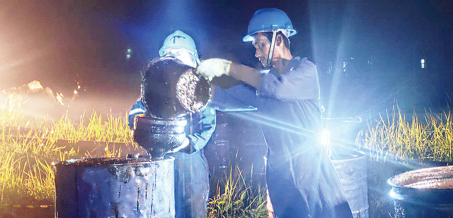 BERSIHKAN MINYAK: Salah seorang karyawan PT Imbang Tata Alam member&shy;sihkan tumpahan minyak akibat kebocoran pipa di Desa Bagan Melibur, Kecamatan Merbau, Kabupaten Kepulauan Meranti, Kamis (9/10/2025).