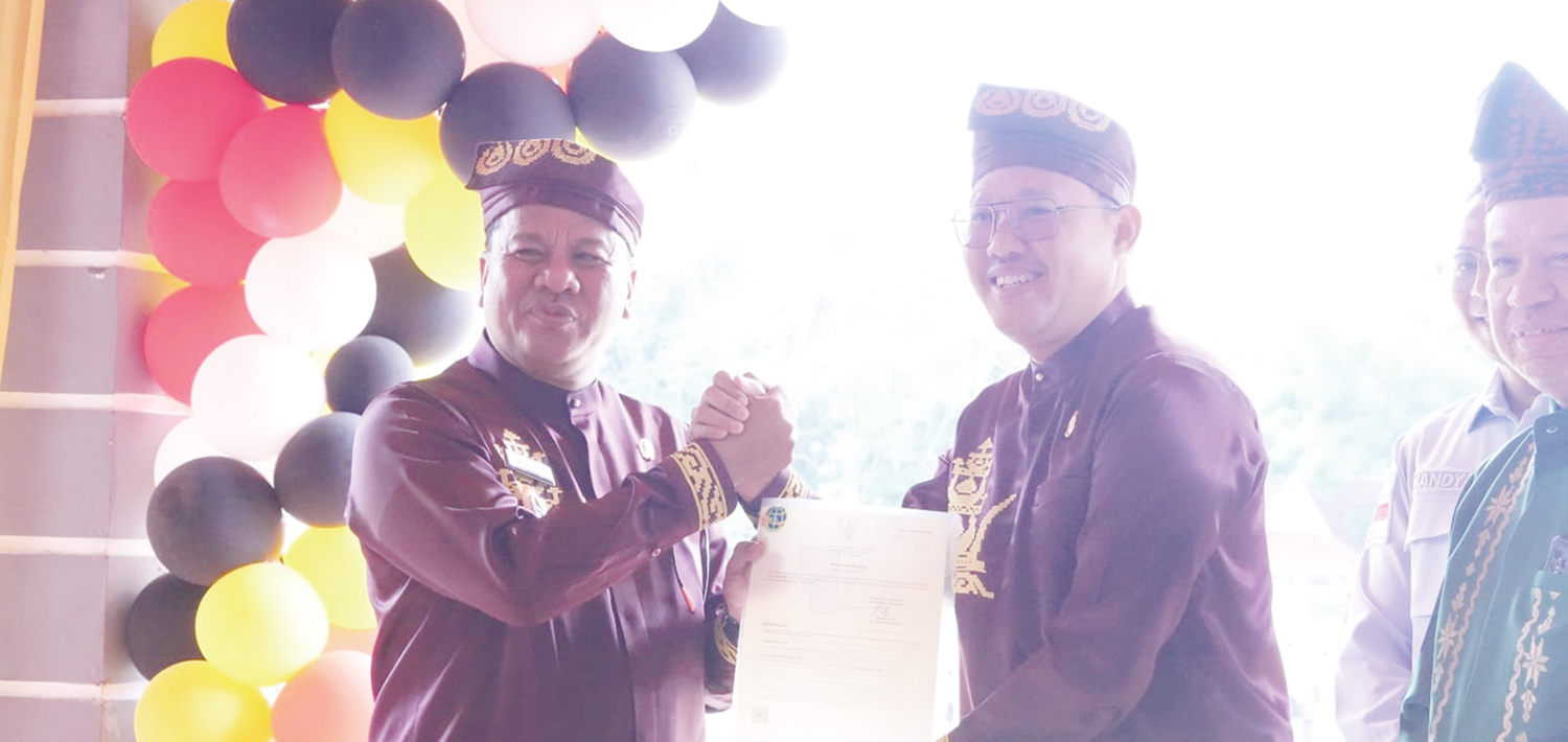 Kejari Kuansing Sahroni SH MH menyerahkan sertifikat tanah milik pemkab kepada Bupati Kuansing Suhardiman  Amby MM usai upacara HUT Kuansing di Lapangan Limuno Telukkuantan, Ahad (12/10/2025).