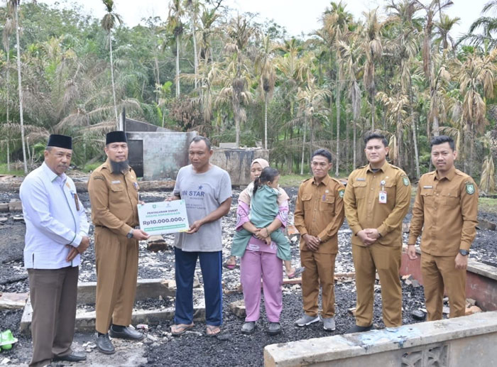 Asisten 1 Setdakab Bengkalis Andris Wasono didampingi Ketua Baznas Ismail dan Camat Bantan Rafli Kurniawan serahkan bantuan kepada korban kebakaran Bunasir di Desa Bantan Sari, Bengkalis