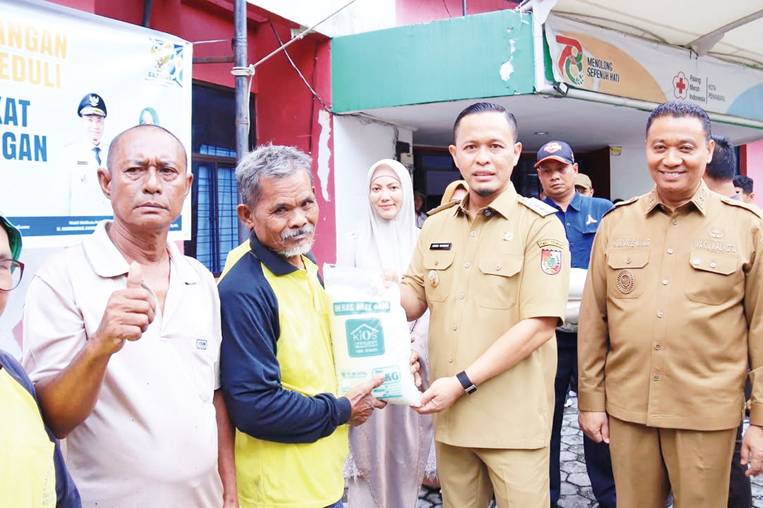 Wali Kota Pekanbaru Agung Nugroho didampingi Wakil Wali Kota Markarius Anwar, dan Ketua TP PKK Pekanbaru Sulastri Agung serta jajaran organisasi perangkat daerah Pemko Pekanbaru menyerahkan bantuan beras kepada petugas kebersihan di Kantor Dinas Ketahanan