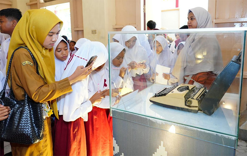 Guru pendamping bersama murid SD menyaksikan mesin tik dalam Pameran Teknologi Koleksi Museum Budaya dan Sejarah Siak Balairung Sri, Selasa (14/10/2025).