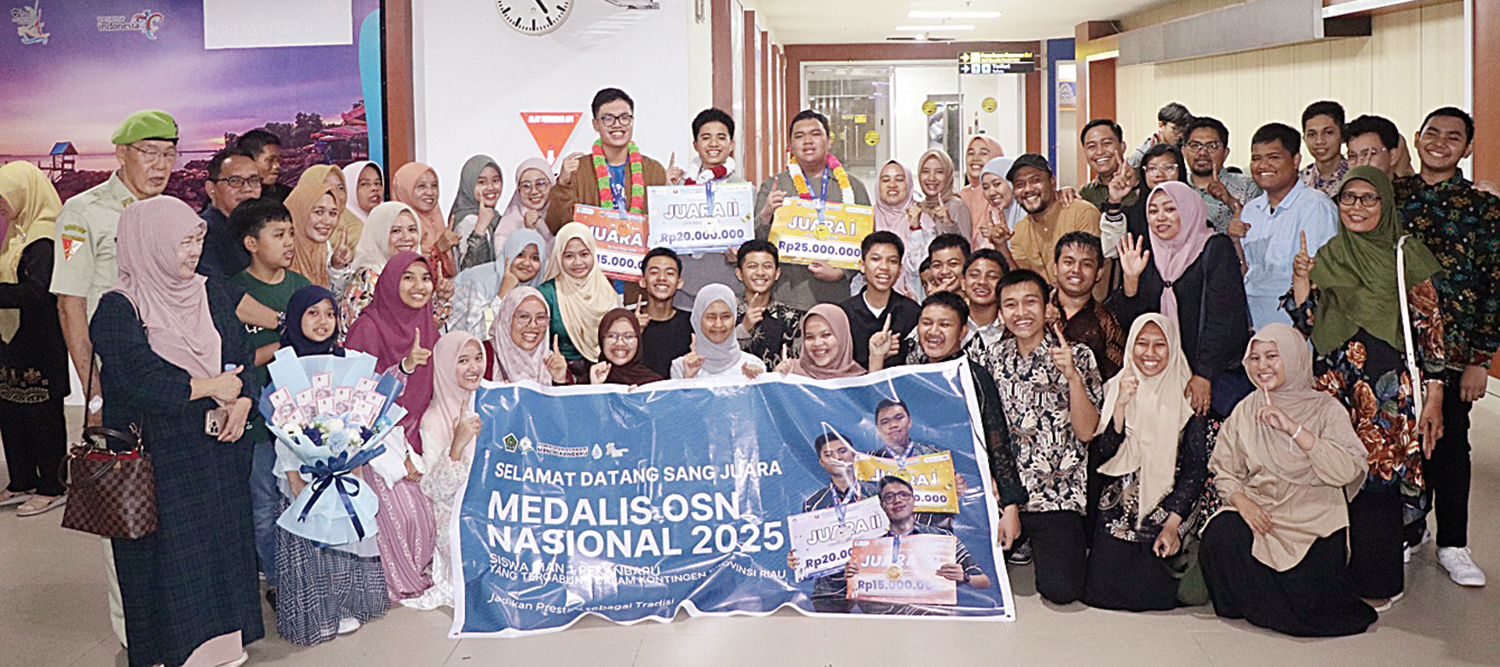 FOTO BERSAMA: Keluarga besar MAN 1 Pekanbaru foto bersama pada saat penyambutan delegasi OSN MAN 1 Pekanbaru di Bandara Sultan Syarif Kasim II Pekanbaru, Ahad (12/10/2025).