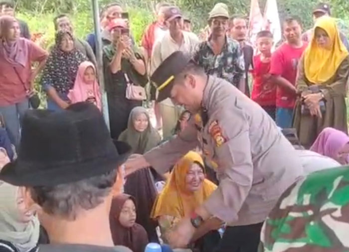 Kapolsek Rupat AKP Faisal membagi-bagikan air mineral kepada masyarakat yang menggelar aksi demo di Rupat, Kamis (16/10/2025).