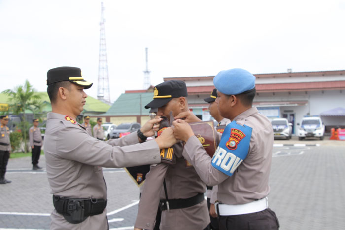 Kapolres Inhu AKBP Fahrian Saleh Siregar SIK MSI memasangkan band lengan secara simbolis kepada perwakilan anggota dari berbagai fungsi, Kamis (16/10/2025)